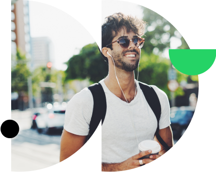 Homem de óculos e fones de ouvido caminhado na rua